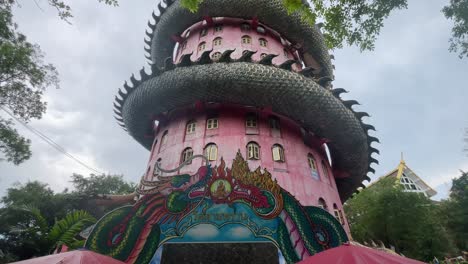 Unique-and-impressive-Wat-Samphran-features-a-17-story,-bright-pink-tower-with-a-dragon-coiling-around-it-in-Nakhon-Pathom-province,-West-of-Bangkok,-Thailand