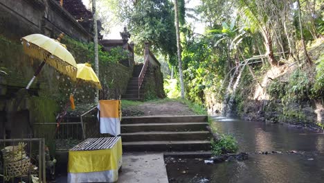 Water-Temple-Atmosphere-in-Bali-Indonesia-around-a-River,-Trees-and-Forest-with-Umbrellas-and-a-Hindu-Shrine,-Balinese-Hinduism,-Samuan-Tiga