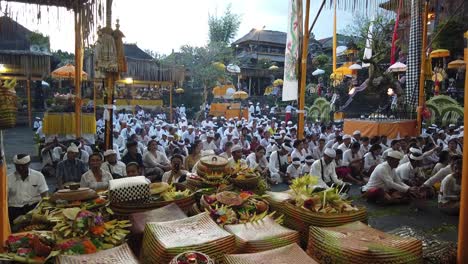 Balinesen-Beten-In-Massen-In-Der-Hinduistischen-Tempelzeremonie-In-Der-Abenddämmerung,-Bunte-Kokosnussopfer-Und-Blumen-Rund-Um-Samuan-Tiga-Bedulu