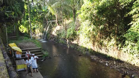Los-Hindúes-Caminan-Alrededor-Del-Santuario-Del-Bosque-En-Bali-Indonesia,-El-Río-Verde-Del-Bosque-Y-El-Flujo-De-Agua-En-Samuan-Tiga,-Indonesia