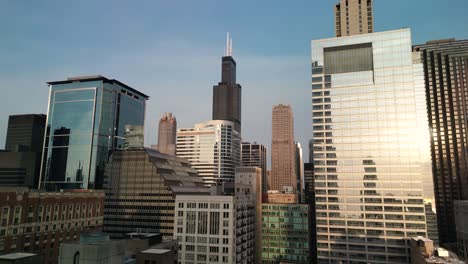 Aerial-pan-up-to-Willis-Tower,-downtown-Chicago,-sunset---Drone-4k