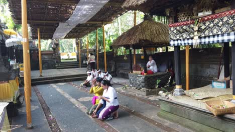 Women-Prays-inside-a-Balinese-Temple-getting-into-a-Spiritual-Experience,-Outdoors-Ceremony-of-Hindu-Bali-Tradition,-Samuan-Tiga
