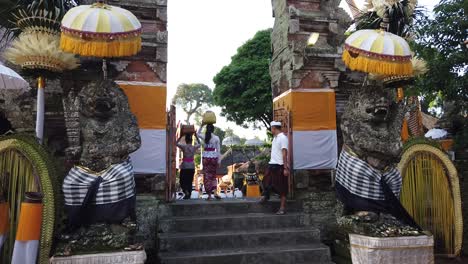 Mujeres-Balinesas-Vestidas-Con-Ropas-Tradicionales-Entran-Por-La-Puerta-Principal-Del-Templo-Samuan-Tiga-En-Blahbatuh-Durante-Una-Ceremonia-Hindú