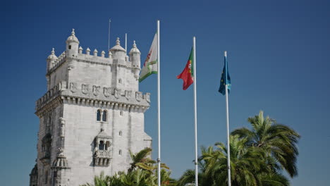 Portugal,-EU-and-Portuguese-Navy-flags-in-front-of-Torre-de-Belem-medium-long-shot
