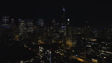 Aerial-view-around-the-illuminated-skyline-of-downtown-Chicago,-night-in-USA