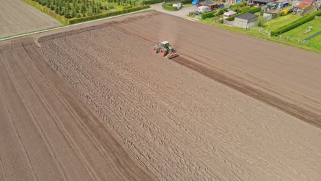 Beautiful-aerial-of-tractor-plowing-a-empty-plot-of-land-on-a-sunny-day