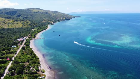 Aerial-drone-view-of-tourism-dive-boat-cruising-around-coral-reef-ecosystem-in-beautiful-turquoise-blue-ocean-of-Atauro-Island-in-Timor-Leste,-Southeast-Asia