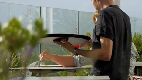 Refreshing-Red-Fruit-Cocktail-Served-to-a-Redheaded-Man-on-Terrace