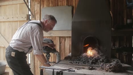 A-blacksmith-reenactor-brings-history-to-life-by-portraying-a-traditional-blacksmith,-showcasing-the-art-and-trade-of-metalworking-with-authentic-tools-and-methods