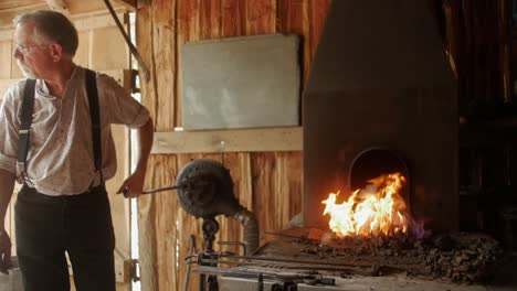 A-blacksmith-reenactor-brings-history-to-life-by-portraying-a-traditional-blacksmith,-showcasing-the-art-and-trade-of-metalworking-with-authentic-tools-and-methods