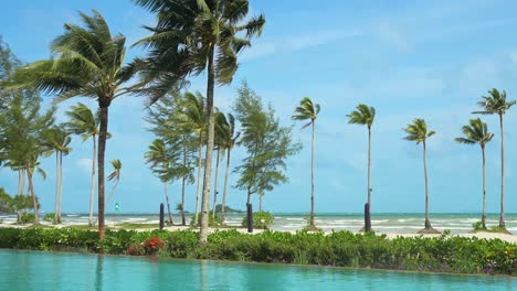 The-view-of-the-beach-with-palm-trees-as-seen-from-the-grounds-of-the-luxury-Sanchaya-Resort-on-Bintan-Island,-Riau-Islands,-Indonesia