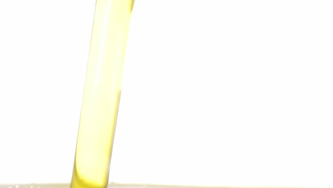 Ein-Angenehmer-Fluss-Gelben-Olivenöls,-Der-In-Einen-Transparenten-Behälter-Fällt,-Mit-Schönen-Aufsteigenden-Luftblasen