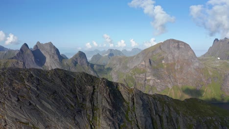 Drone-shot-of-Lofoten-steep-cliffs-and-mountains-rising-from-deep-blue-sea