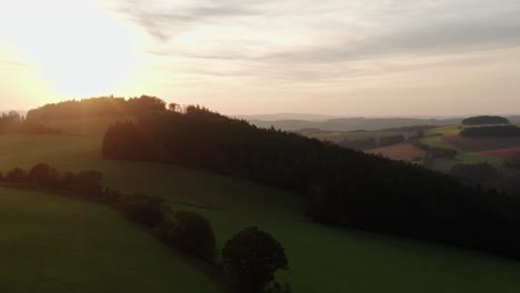Done-shot-of-sunset-over-hills,-fields,-meadows-and-forest-in-Czech-countryside