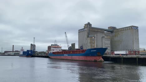 Time-Lapse-of-the-Docks-of-Cork,-Cranes-are-unloading-a-Freighter-Ship