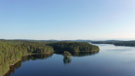 Drone-shot-of-crystal-clear-lake-in-Sweden-inland-surrounded-by-deep-forest-landscape