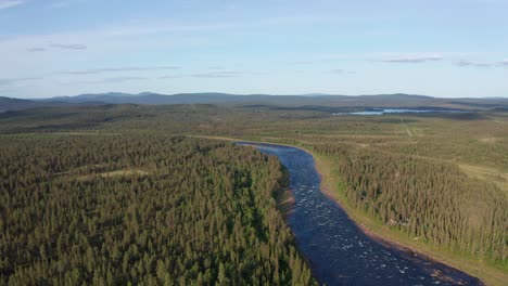 Drone-shot-of-wild-river-in-northern-Sweden-surrounded-by-deep-forest