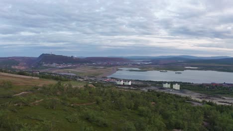 Drone-shot-of-Kiruna-iron-mine-countryside-during-sunset-with-mountains-on-the-horizon
