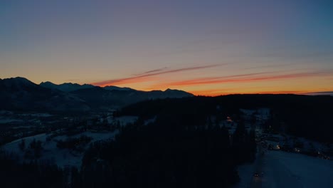Sonnenuntergang-Drohne-Luftaufnahme-Dolly-Abstieg-Winterschnee-Mit-Vorbeifahrendem-Auto