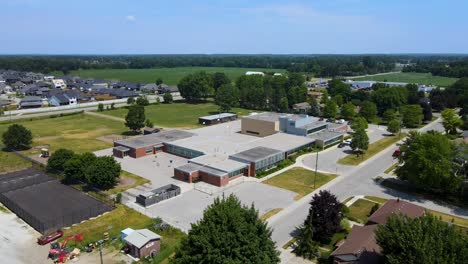 Drone-flying-towards-a-London,-Ontario-school-on-a-bright-sunny-day
