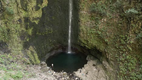 People-relaxing-by-Caldeirao-Verde-waterfall-after-hiking,-Madeira-portugal,-aerial-view