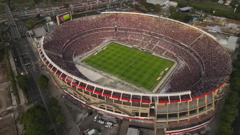 A-dynamic-aerial-shot-of-a-live-professional-football-game-at-the-Monumental-Stadium-in-Buenos-Aires-City,-Argentina