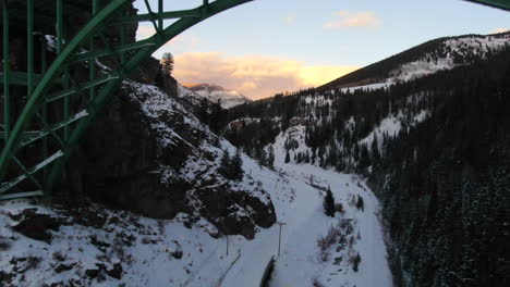 Luftkino-Drohne-Vail-Avon-Red-Cliff-Ikonisches-Colorado-Unter-Der-Brücke-Mitten-Im-Winter-Im-Schnee-Später-Sonnenuntergang-Rückwärtsbewegung