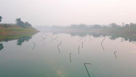 Misty-foggy-spooky-Surma-River,-low-aerial,-backwards,-Bangladesh-mist