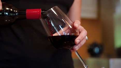 Woman-pouring-wine-into-a-wine-glass-at-a-restaurant