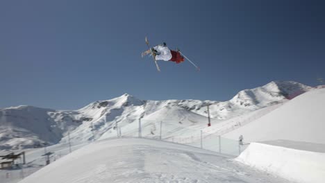 Freestyle-Aerial-Skiing,-Slow-Motion-of-Skier-Launching-From-Kicker-in-the-Air-and-Landing-on-Snow