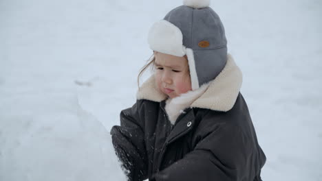 Baby-Girl-Playing-With-Snow-And-Squeezing-By-Hand-Then-Goes-To-Her-Eyes