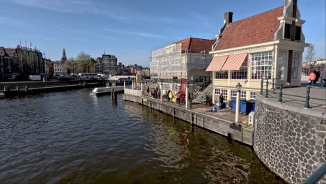 Touristen-Warten-Neben-Dem-Pier-Auf-Eine-Grachtenrundfahrt-In-Amsterdam