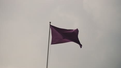 Purple-Flag-Swaying-With-The-Wind-During-Holy-Week-In-Antigua-Guatemala---low-angle