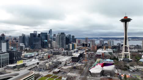 Aerial-view-across-Seattle-business-district-skyscrapers-and-Space-Needle-under-overcast-cityscape-skyline
