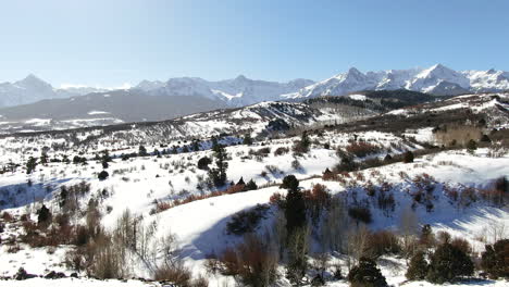Aerial-Cinematic-drone-mid-winter-of-San-Juan-Mountain-Range-Ridgway-Telluride-14er-stunning-ranching-farm-land-of-Colorado-early-morning-mid-winter-blue-sky-pan-to-the-right-movement