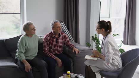 Arzt-Spricht-Mit-älterem-Paar-Zu-Hause-Oder-Im-Pflegeheim