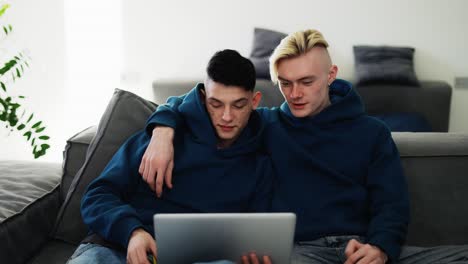 Loving-gay-couple-spend-time-at-home,-watching-movie-together-on-laptop