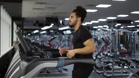Fitness-Mann-Trainiert-Cardio-Training-Auf-Laufgerät-Im-Fitnessstudio,-Seitenansicht