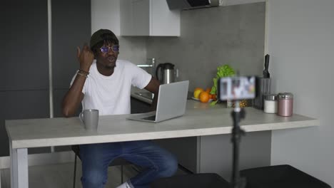 Black-male-blogger-talking-to-the-subscribers,-recording-video-on-camera,-streaming