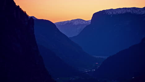 Settlement-in-valley-nestled-by-huge-mountains-at-sunset