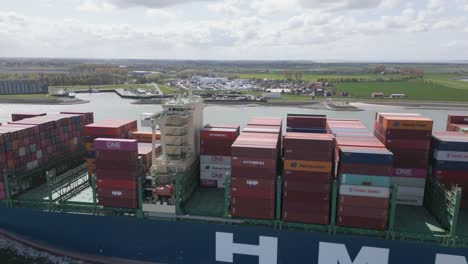 Aerial-flying-over-container-ship-heading-towards-Dutch-coast-city