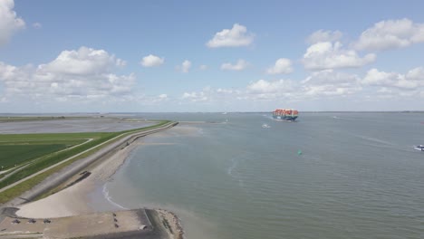 Panoramic-view-of-Dutch-coast,-cargo-ship-in-background