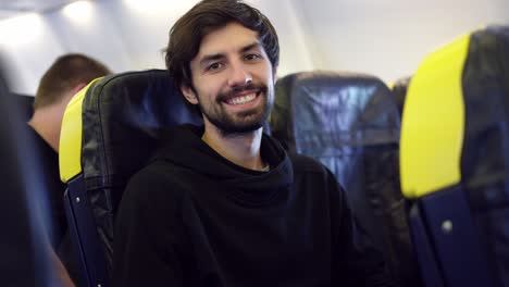 Man-enjoying-his-journey-by-airplane,-smiling-to-the-camera