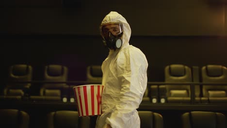 Ein-Mann-In-Weißem-Schutzkostüm-Und-Atemschutzmaske-Kam-Allein-Mit-Einem-Eimer-Popcorn-Ins-Kino