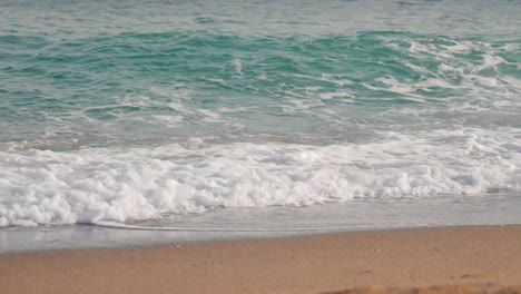 Soft-ocean-waves-hitting-the-sandy-beach-on-a-sunny-day
