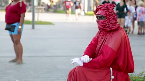 Street-performer,-statue,-dressed-in-red-at-Praca-Maua,-in-the-center-of-Rio-de-Janeiro,-Brazil,-on-a-Sunday-afternoon