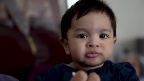 Slow-motion---caucasian-baby-chewing-snack-and-looking-at-camera