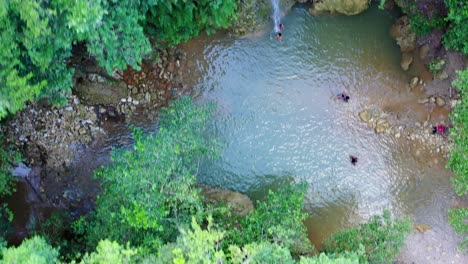 Touristen-Schwimmen-Im-Kühlen-Wasser-Unter-Dem-Wasserfall-El-Limon-In-Samana,-Dominikanische-Republik
