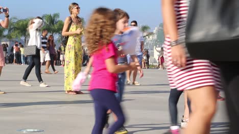 Children-eating-cotton-candy,-people-taking-photos-with-their-phones,-woman-in-yellow-dress,-in-front-of-Museu-do-Amanha,-Tomorrow's-museum,-at-Praca-Maua,-in-Rio-de-Janeiro,-Brazil