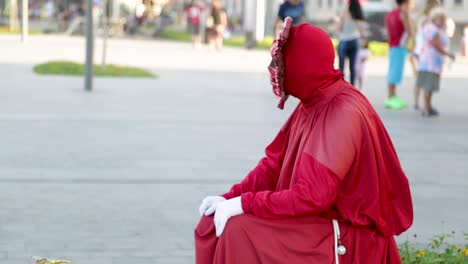 Street-performer,-statue,-dressed-in-red-at-Praca-Maua,-giving-thumbs-up,-joinha,-in-the-center-of-Rio-de-Janeiro,-Brazil,-on-a-Sunday-afternoon